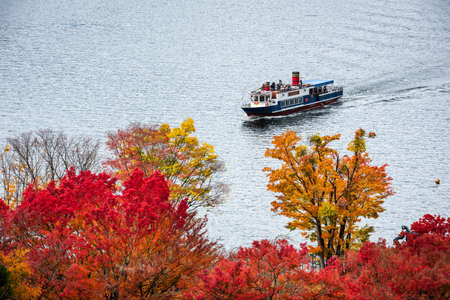 A tour boat on Lake Kawaguchi, Japan during the autumn season.