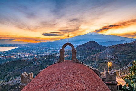Taormina, Sicily, Italy with the ancient Church of San Biagio and Mt. Etna at dusk.の写真素材