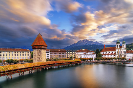 Lucern, Switzerland with the Chapel Bridge over the River Reuss with Mt. Pilatus in the distance at dusk.の写真素材