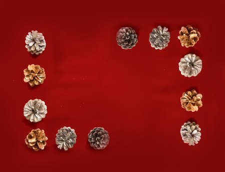 creative frame out of pine cones on a red velvet background for Christmas decoration