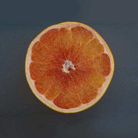 Half of a red grapefruit on a dark gray background, top viewの写真素材