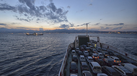 Messina's Channel, Italy - October 03, 2014: Full ferry crossing the Channel at sunset.
