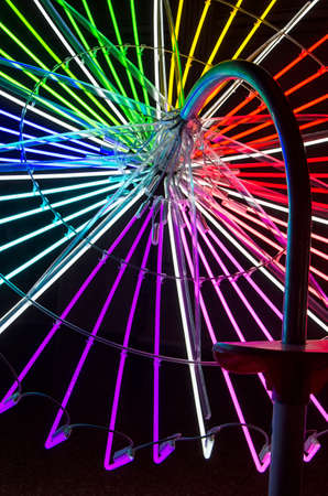 View of umbrella structure composed of neon tubesの写真素材