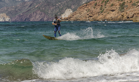 Porto Paglia, Italy - October 03, 2016: Senior keeps active by practicing kitesurf in Sardinia