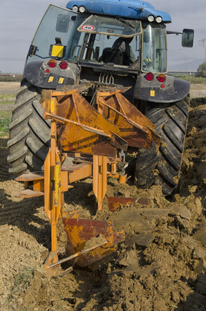 View of tractor that plows the landの写真素材