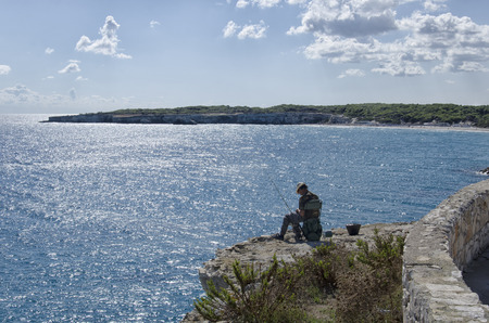 Torre dell'Orso, Italy - September 22, 2017: Solitary angler engaged in bait preparationのeditorial素材