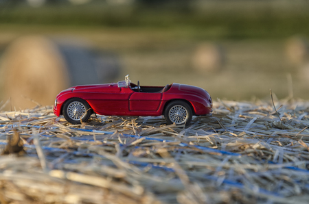 View of a luxury auto on a straw round baleの写真素材