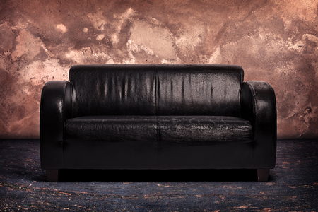 Old leather couch on sandstone backgroundの写真素材
