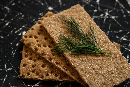 Rye breads lie on a black background. Crispbread. Diet