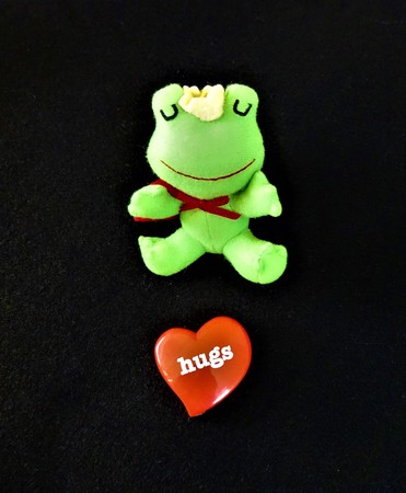 A cute stuffed frog with a heart shaped objectの写真素材