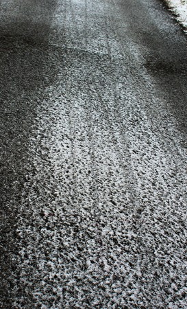 Tire tracks on an icy toad in winterの写真素材