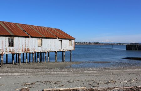 An old building on a run down pier in a bay