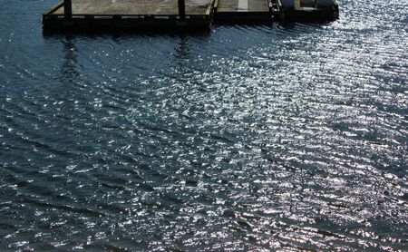 Sunlight creates a shiny ripple reflection on water in the bay