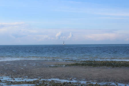 A sailboat at low tide view from a Pacific Northwest beachの写真素材
