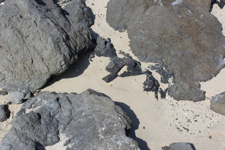 Sand accumulated between the boulders on a beachの写真素材