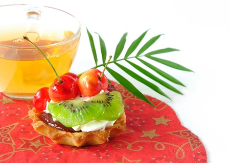 Fruit cake and cup of green tea on a white backgroundの写真素材