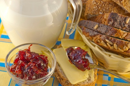 Jug with milk, bread and jam on a blue backgroundの写真素材
