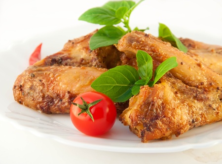 Chicken wings a grill with a tomato and a basilの写真素材