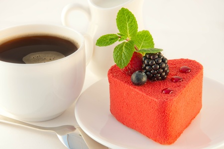 Cake in the form of heart with a blackberry, a raspberry and mint, a cup of coffee
の写真素材