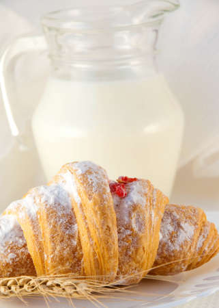 Croissant with jam and a milk jug, a light morning mealの写真素材
