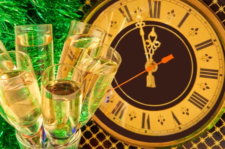 Christmas card. Glasses of champagne on New Year's Eve against an ancient wall clockの写真素材