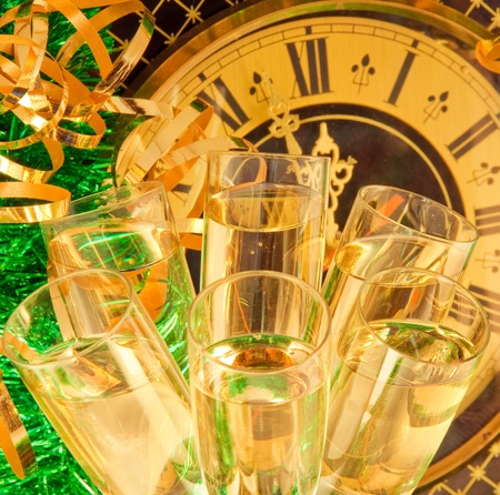 Christmas card. Glasses of champagne on New Year's Eve against an ancient wall clockの写真素材