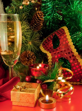 Christmas card. Champagne, a branch of a fur-tree, a candle and a carnival maskの写真素材