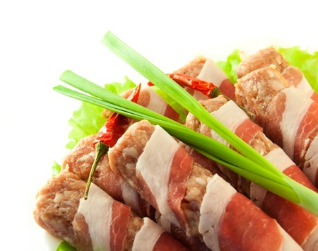 Meat roll with bacon, an onions and pepper, green saladの写真素材
