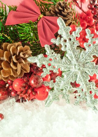 Christmas branch of berries with a silver decorative snowflake against snowの写真素材