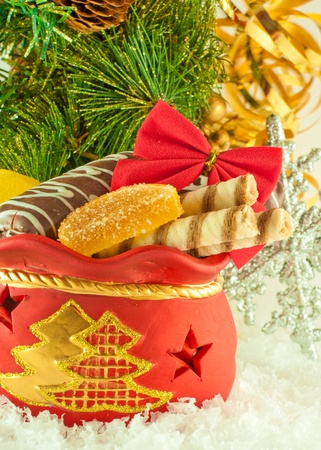 Christmas bag with gifts, cookies and fruit candy, a fur-tree branchの写真素材