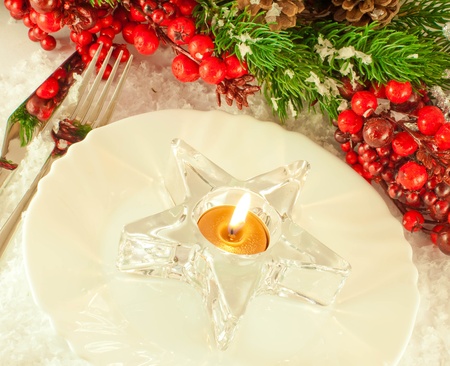 Christmas table layout, candlestick in the form of a star with a branch of berriesの写真素材