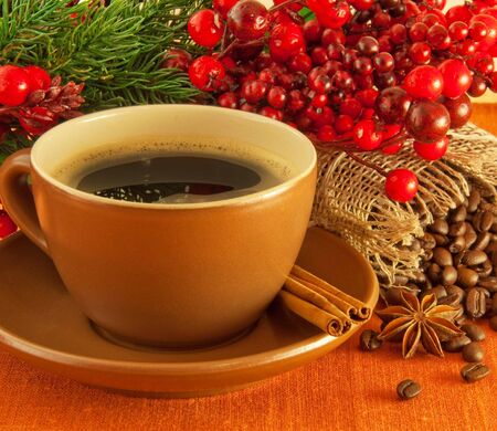 Christmas branch from berries and a fur-tree and a cup of coffeeの写真素材