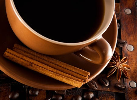 Cup of coffee on grange a background, coffee grains and cinnamonの写真素材