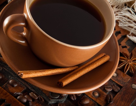 Cup of coffee on grange a background, coffee grains and cinnamonの写真素材