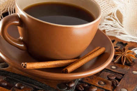 Cup of coffee on grange a background, coffee grains and cinnamonの写真素材