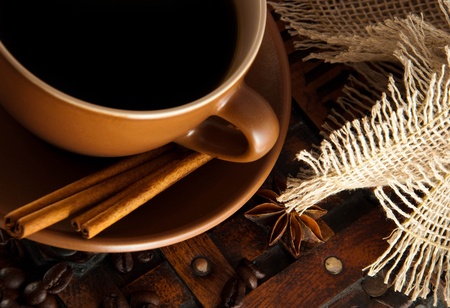 Cup of coffee on grange a background, coffee grains and cinnamonの写真素材