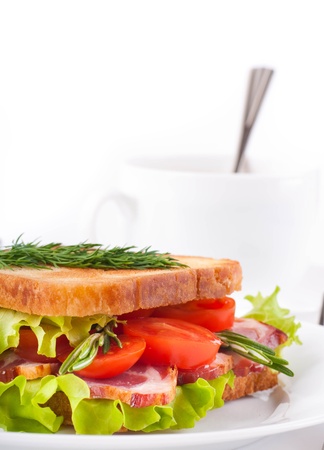 Sandwich from smoked meat and tomatoes, a cup of coffeeの写真素材
