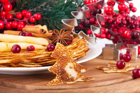 Pancakes with christmas berries and pastry forms of fir-tree and starの写真素材