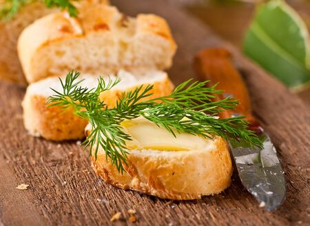 Fresh bread and butter on a wooden boardの写真素材