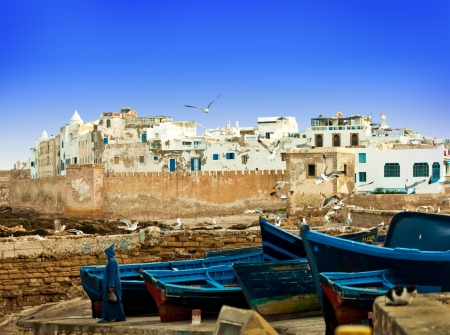Blue fishing boats on an ocean coast in Essaouira, Moroccoの写真素材