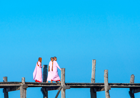 Mandalay - December 1: U-Bein Bridge December 1, 2013 in Mandalay. Monks crossing the river on the...