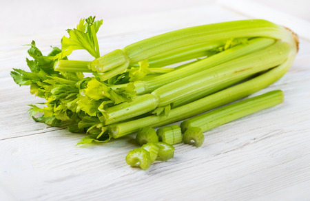 Green celery on a white wooden boardの写真素材