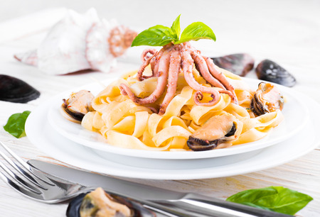 Pasta with mussels and octopus on wooden backgroundの写真素材