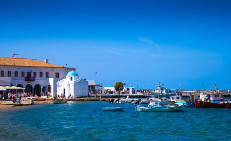 Greek island with colorful houses and yachts.