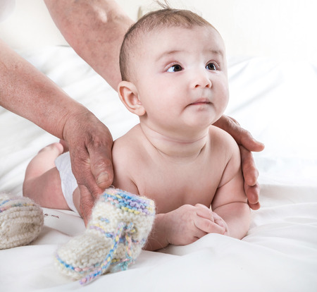 Grandmother knitted baby socks warm , caring for the childの写真素材