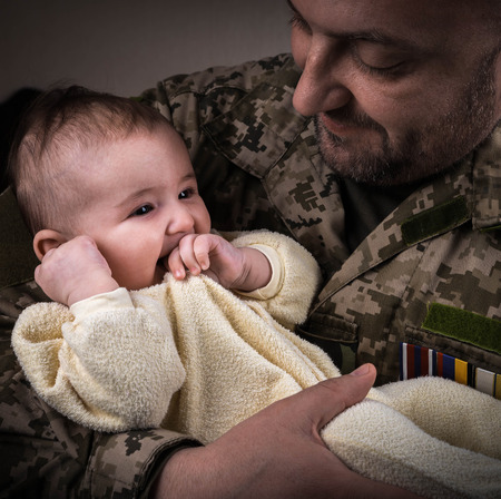 Kids Against War. The child in the arms of a soldier.の写真素材
