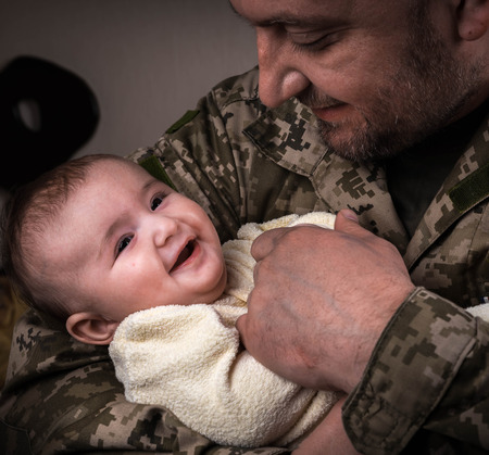 Kids Against War. The child in the arms of a soldier.の写真素材