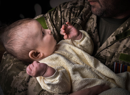 Kids Against War. The child in the arms of a soldier.の写真素材