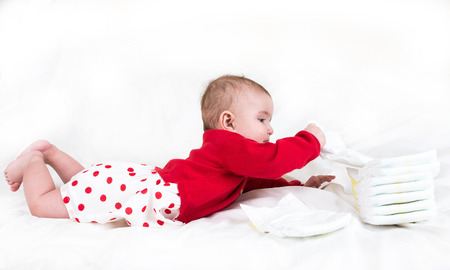 The child in bright clothes and diapers on a white backgroundの写真素材