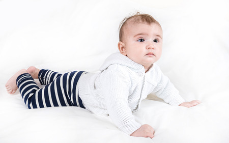 The child in bright clothes and diapers on a white background